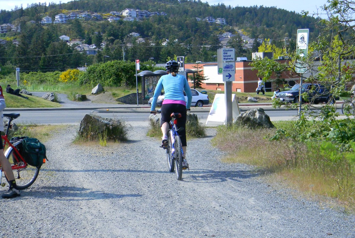 A cyclist approaching the end of a bike path that ends right onto a five lane highway.
