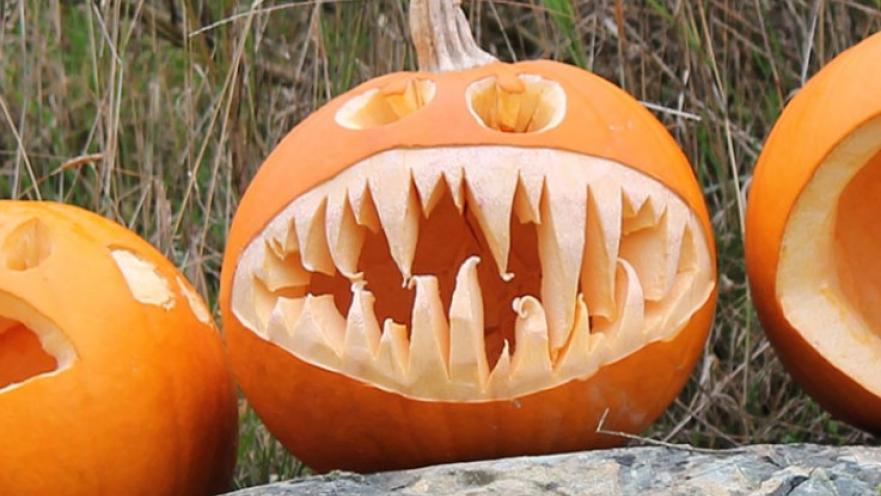 Pumpking carving in the shape of an anglerfish. The pumpkin is bright orange.