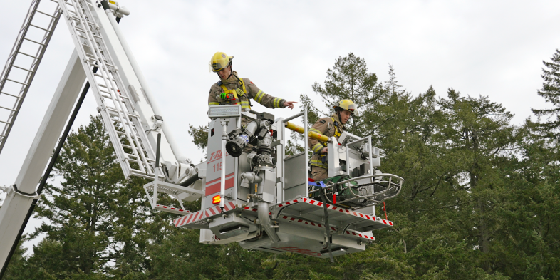 Colwood firefighters in hi rise lift above the trees