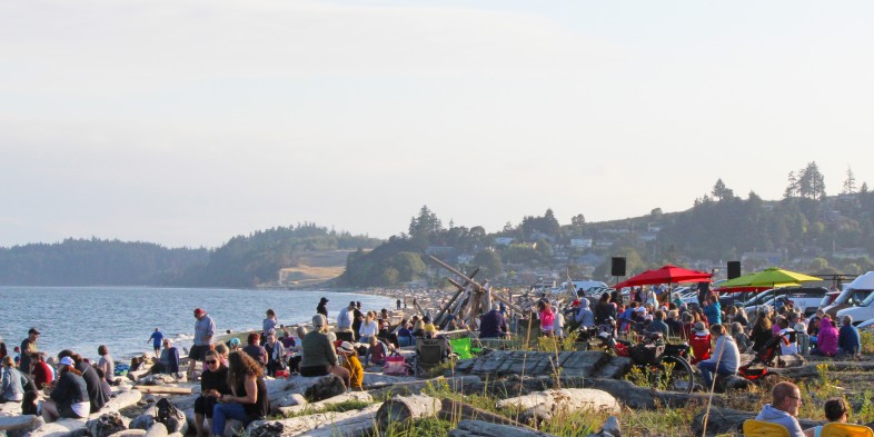 crowd of people relaxing on beach chairs while live band plays music
