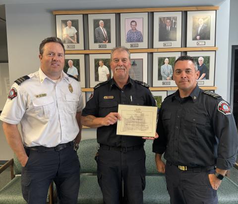 three firefighters presenting award