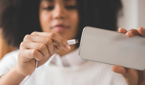 girl plugging in phone charger