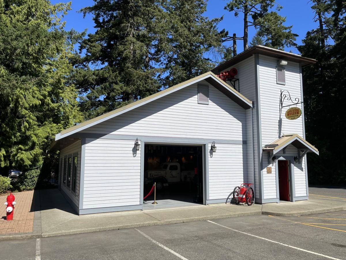 Exterior view of the Colwood Firehouse Museum surrounded by trees.